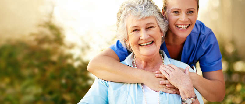 caregiver hugging elderly lady