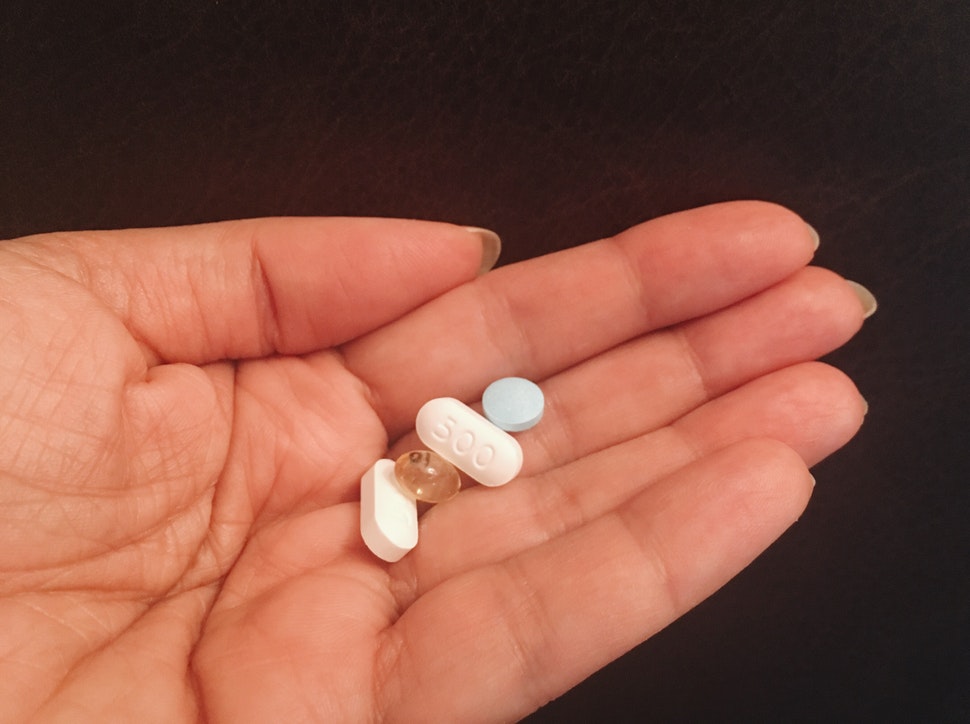 a hand carrying 4 pills