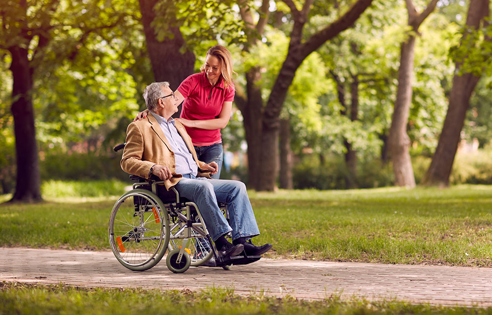 a woman helping an elderly man in a wheelchair