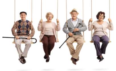 two senior men and one senior woman having fun in playground swings